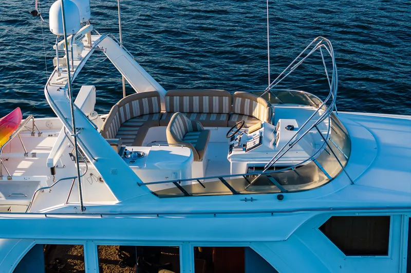 Slide: The Image of Luxurious 2001 Navigator 61' Pilothouse yacht with spacious deck and seating, cruising on water. - 15