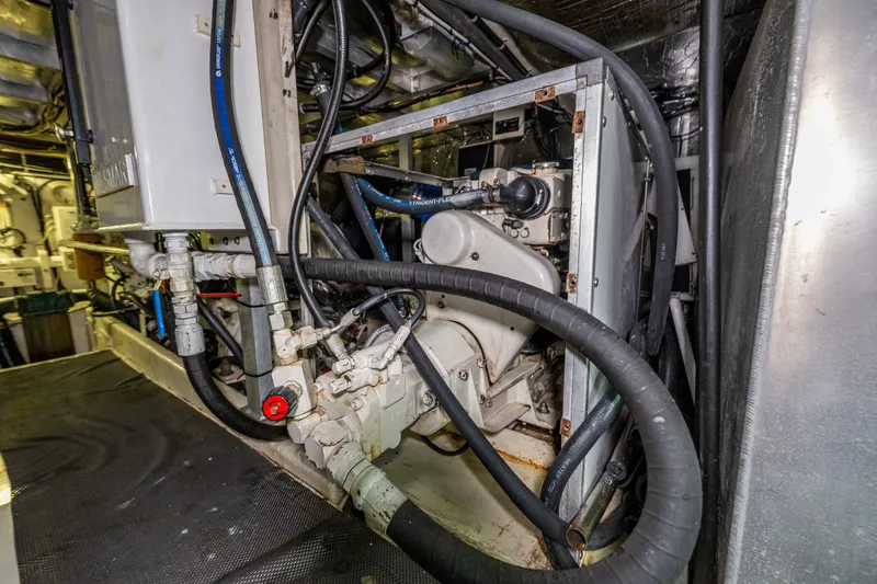 Slide: The Image of Engine room of 2001 Navigator 61' Pilothouse yacht with visible machinery and hoses. - 83