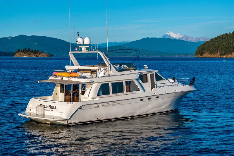 Slide: The Image of 2001 Navigator 61' Pilothouse yacht cruising on scenic blue waters with mountainous backdrop. - 25