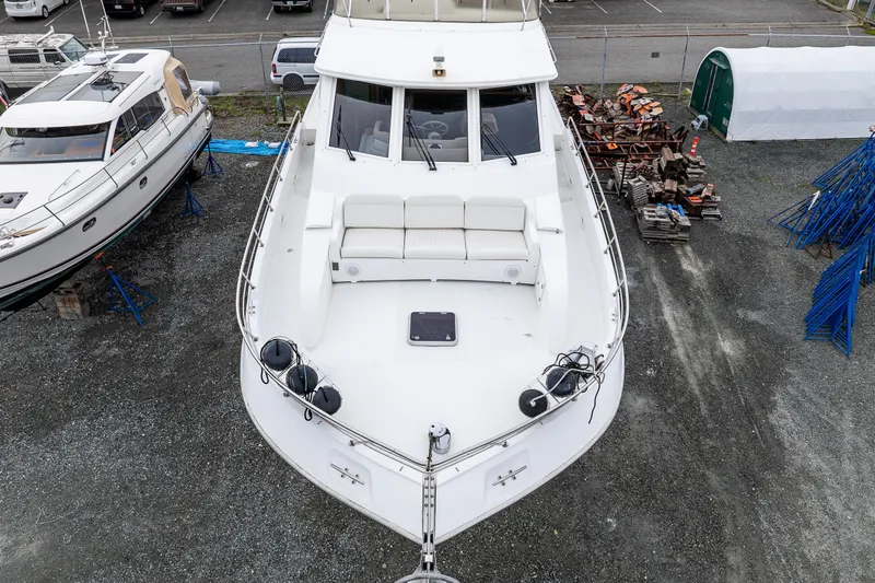 Slide: The Image of 2001 Navigator 61' Pilothouse yacht on dry dock, showcasing spacious deck and seating area. - 42
