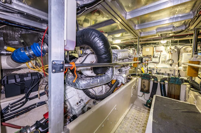 Slide: The Image of Engine room of a 2001 Navigator 61' Pilothouse yacht, showcasing complex machinery and wiring. - 81