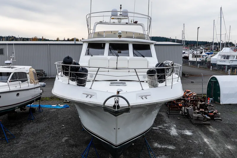 Slide: The Image of 2001 Navigator 61' Pilothouse yacht docked in a marina, surrounded by other boats. - 50