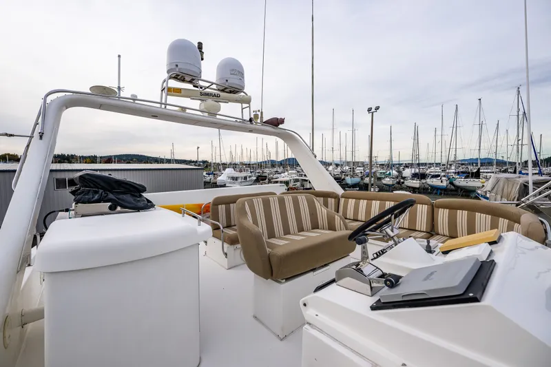 Slide: The Image of 2001 Navigator 61' Pilothouse yacht with striped seating, docked in a marina. - 75