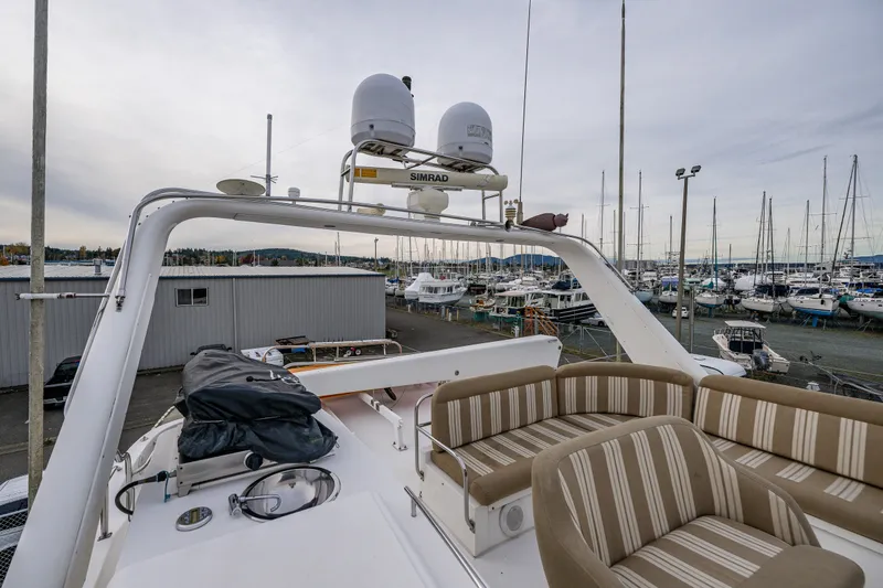 Slide: The Image of 2001 Navigator 61' Pilothouse yacht with striped seating, docked in a marina. - 72