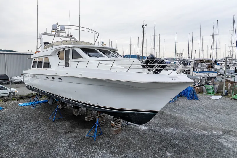 Slide: The Image of 2001 Navigator 61' Pilothouse yacht on dry dock, surrounded by other boats and equipment. - 41