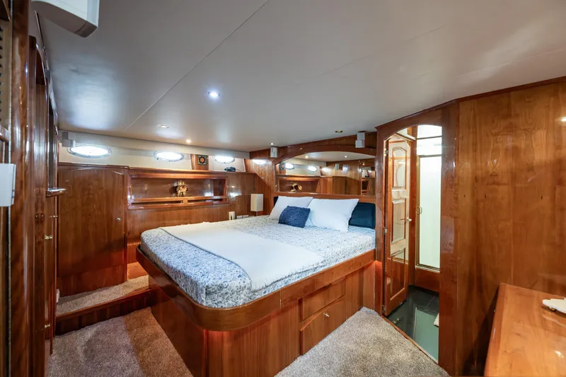 Slide: The Image of Luxurious 2001 Navigator Pilothouse yacht bedroom with wood paneling and cozy bedding. - 13