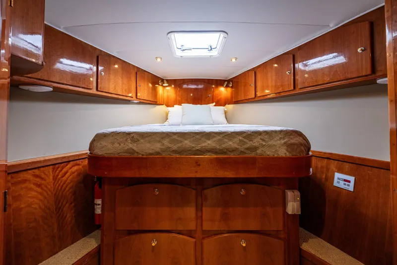 Slide: The Image of Luxurious 2001 Navigator Pilothouse yacht bedroom with wood cabinetry and cozy bedding. - 21