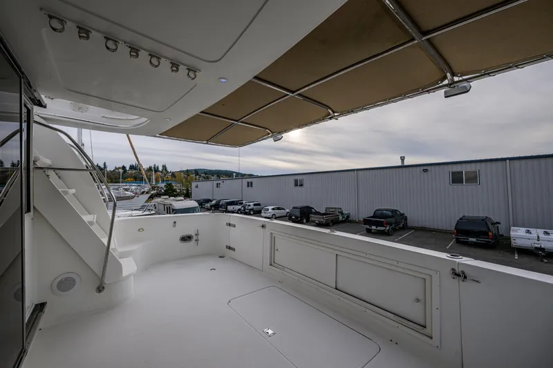Slide: The Image of 2001 Navigator Pilothouse yacht deck with canopy, docked near industrial buildings. - 26