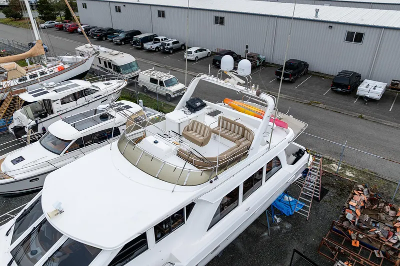 Slide: The Image of 2001 Navigator Pilothouse yacht docked in a marina, surrounded by other boats and vehicles. - 36