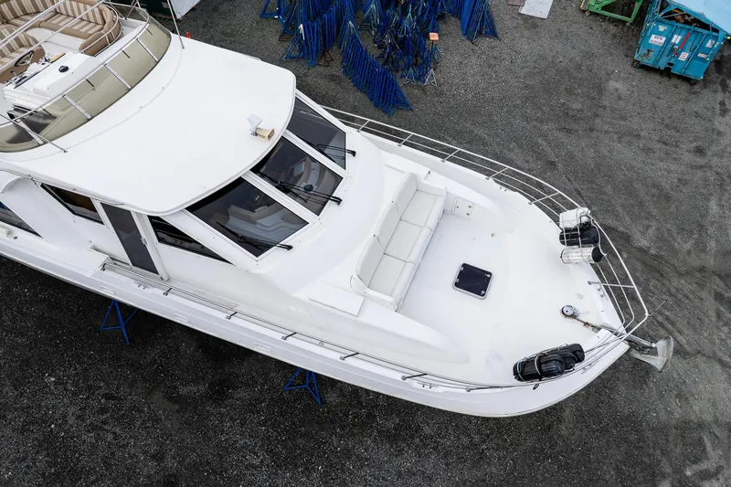 Slide: The Image of Aerial view of 2001 Navigator Pilothouse yacht on dry dock, showcasing spacious deck and seating. - 39