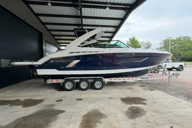 Slide: The Image of 2021 Cruisers Yachts 338 South Beach Edition Bow Rider on trailer in covered area. - 0