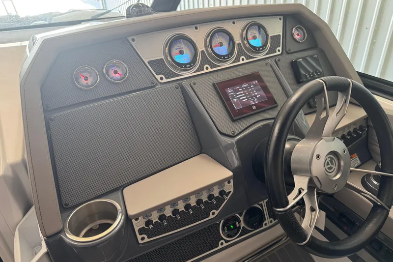 Slide: The Image of 2021 Cruisers Yachts 338 South Beach Edition Bow Rider dashboard with gauges and steering wheel. - 16