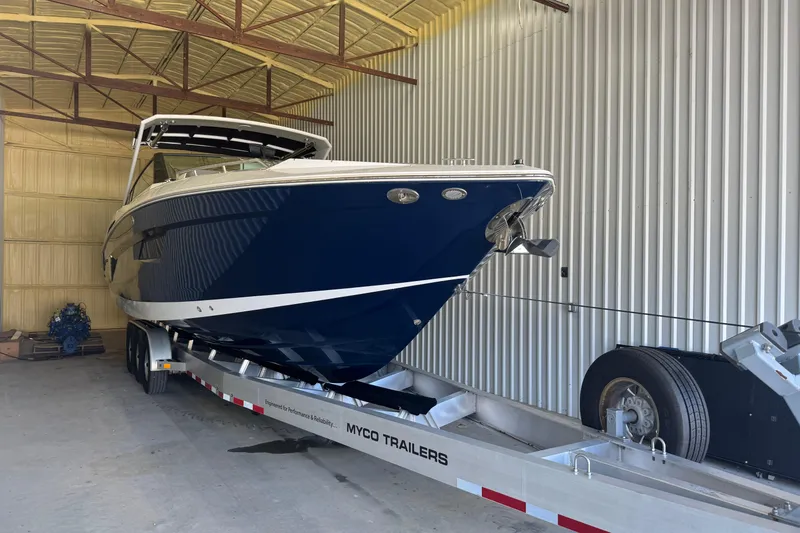 Slide: The Image of 2021 Cruisers Yachts 338 South Beach Edition Bow Rider on trailer in storage. - 2