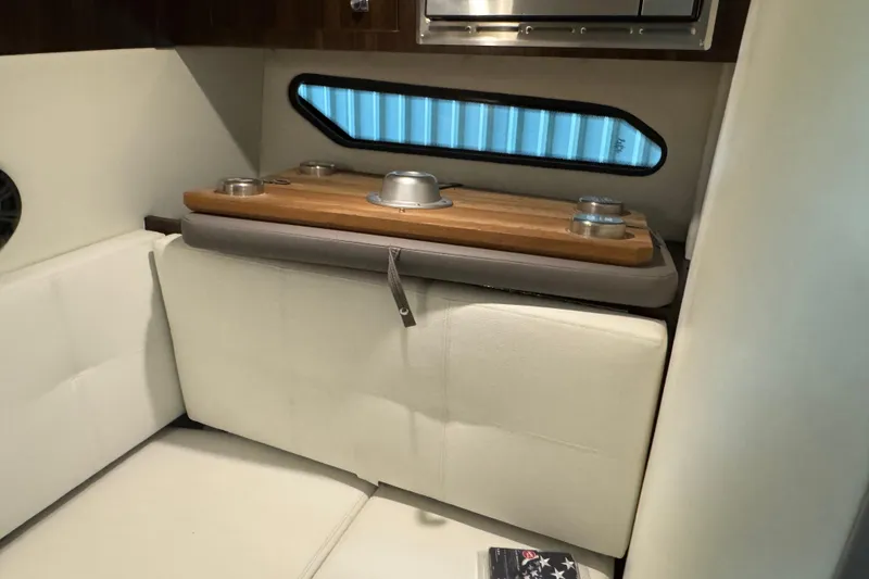 Slide: The Image of 2021 Cruisers Yachts 338 South Beach Edition interior with white seating and wooden table. - 20