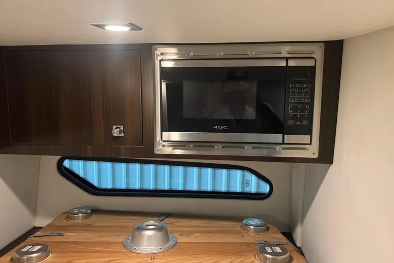 Slide: The Image of 2021 Cruisers Yachts 338 South Beach Edition interior with microwave and wooden cabinetry. - 21