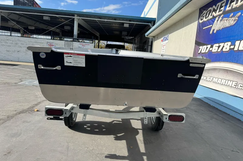 Slide: The Image of 2026 Lund WC-14 boat on trailer, parked outside a marine shop. - 6