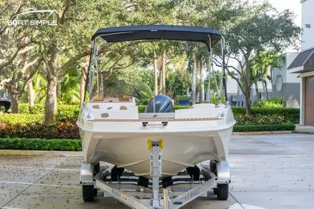 Slide: The Image of 2021 Starcraft SVX 191 OB boat on trailer, parked outdoors with trees in background. - 8