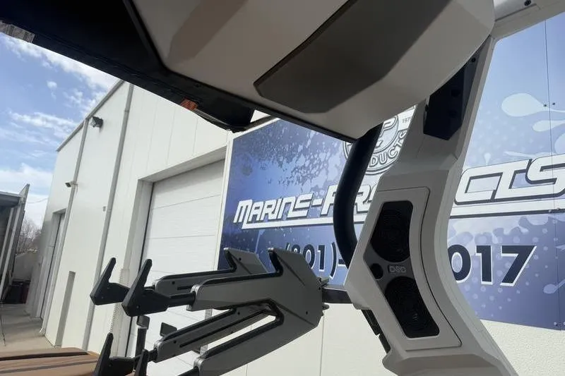 Slide: The Image of 2025 Supra SE 575 boat with advanced wakeboard rack and speakers, near Marine Products building. - 11