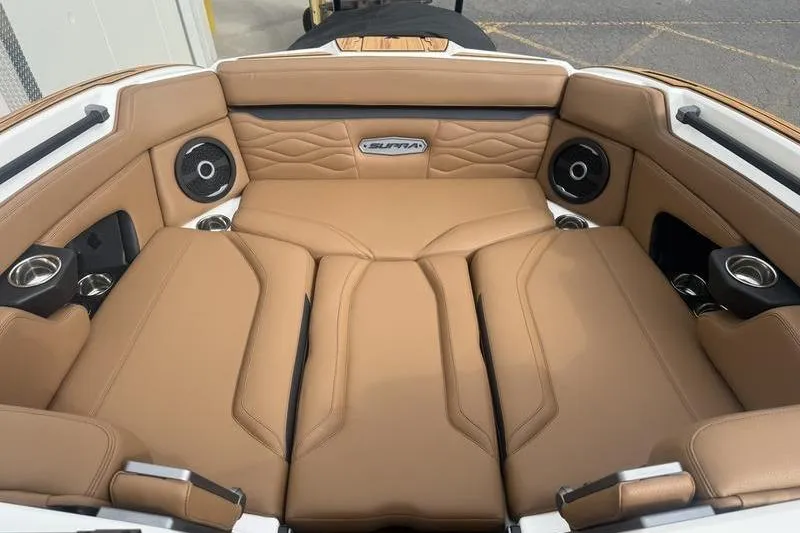 Slide: The Image of 2025 Supra SE 575 boat interior with tan leather seating and built-in speakers. - 12