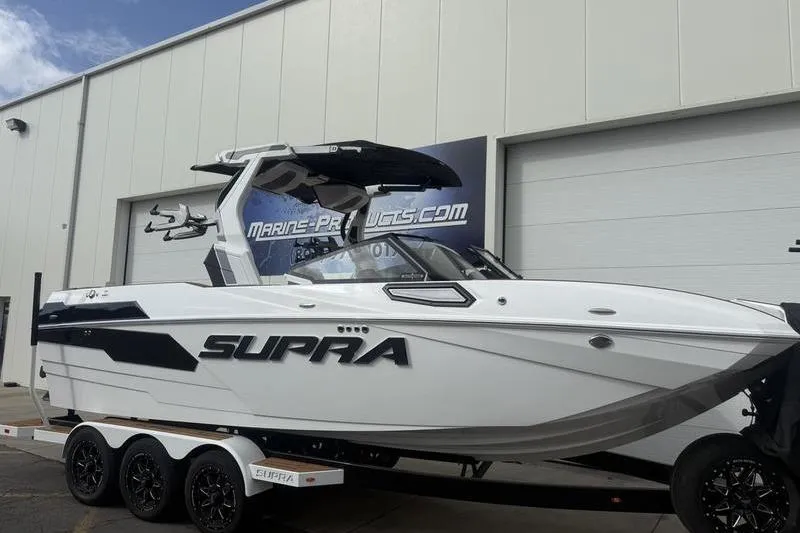 Slide: The Image of 2025 Supra SE 575 boat on trailer outside a marine products store. - 4
