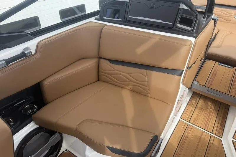 Slide: The Image of Luxurious tan seating in 2025 Supra SE 575 boat interior with wood accents. - 7