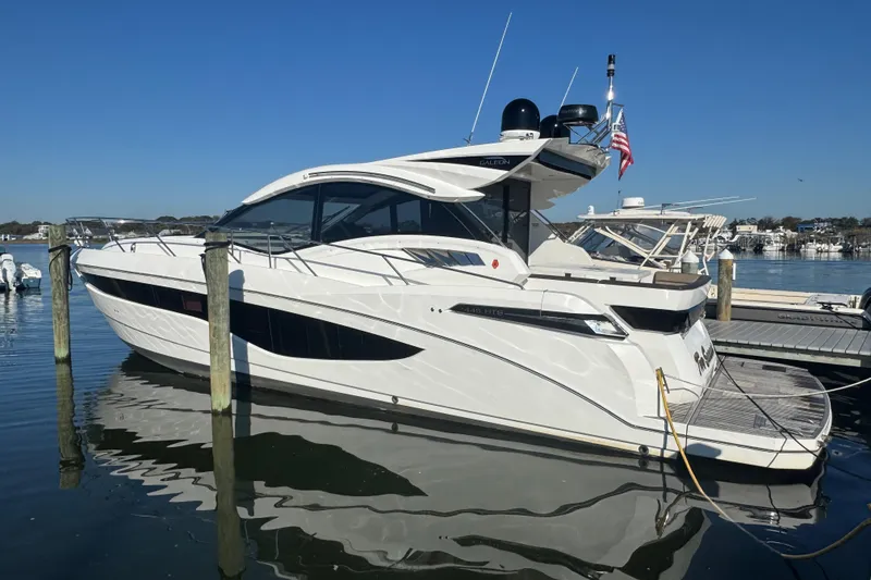 Slide: The Image of 2017 Galeon 445 HTS yacht docked in a marina under clear blue skies. - 11