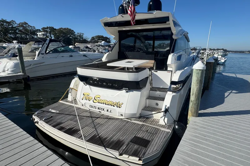 Slide: The Image of 2017 Galeon 445 HTS yacht docked, featuring sleek design and spacious deck. - 13