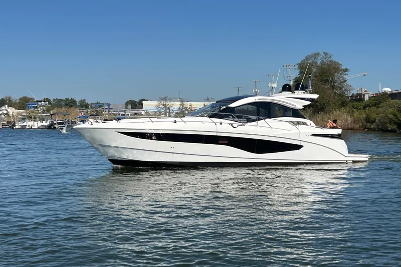 Slide: The Image of 2017 Galeon 445 HTS yacht cruising on a sunny day in a serene waterway. - 2