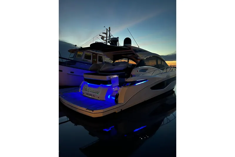 Slide: The Image of 2017 Galeon 445 HTS yacht docked at sunset with blue LED lights. - 5