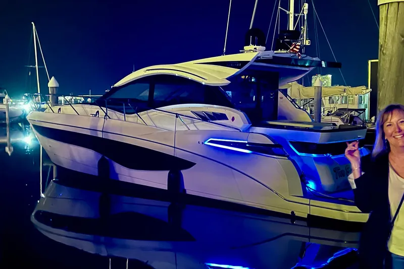 Slide: The Image of 2017 Galeon 445 HTS yacht illuminated at night in a marina setting. - 7