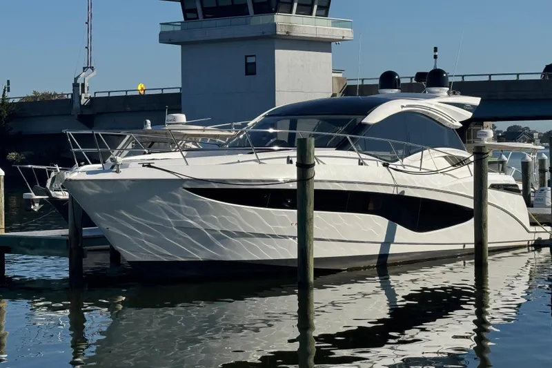 Slide: The Image of 2017 Galeon 445 HTS yacht docked at marina, reflecting on calm water. - 8