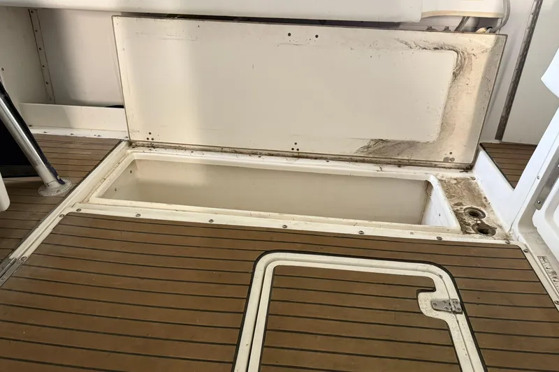 Slide: The Image of Open storage compartment on 2000 Boston Whaler 28 Outrage boat with teak flooring. - 14