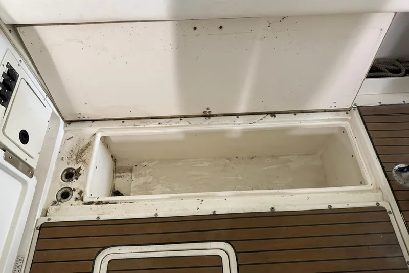 Slide: The Image of Boston Whaler 28 Outrage 2000 boat storage compartment with wooden deck flooring. - 15