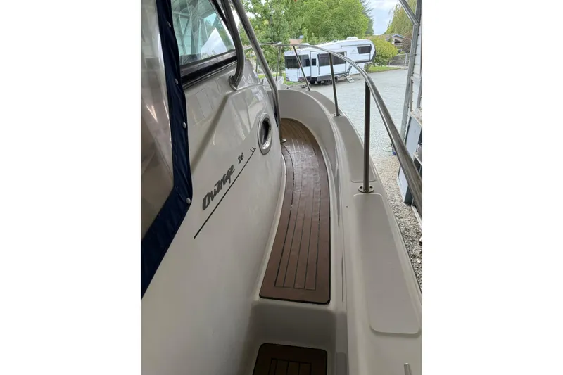 Slide: The Image of 2000 Boston Whaler 28 Outrage boat with wooden deck and railing, parked outdoors. - 22