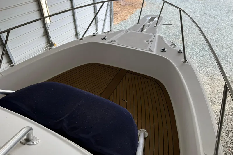 Slide: The Image of 2000 Boston Whaler 28 Outrage boat deck with wooden flooring and railing. - 23