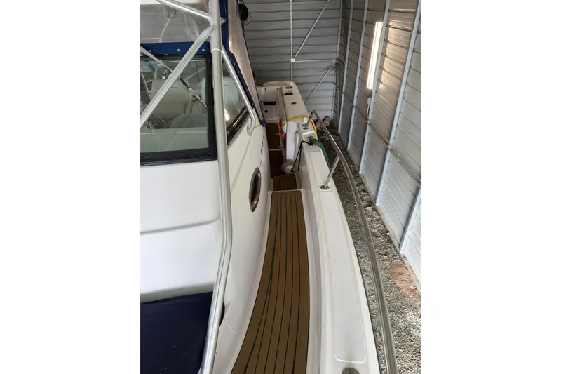 Slide: The Image of 2000 Boston Whaler 28 Outrage boat in storage, side view with railing and deck. - 26