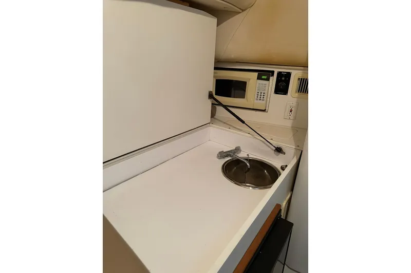 Slide: The Image of Compact kitchenette in a 2000 Boston Whaler 28 Outrage boat, featuring a sink and microwave. - 44