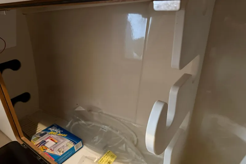 Slide: The Image of Interior storage compartment of a 2000 Boston Whaler 28 Outrage boat with hooks and Ziploc bag. - 49