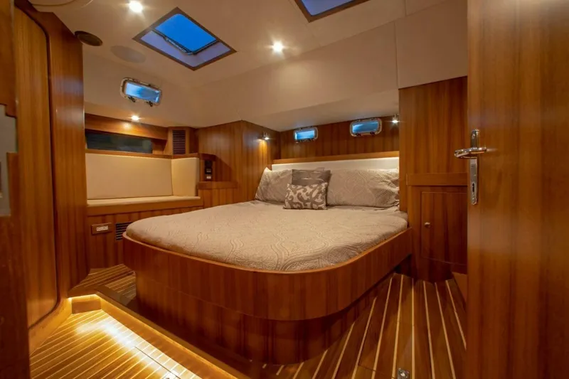 Slide: The Image of Luxurious cabin interior of 2025 Hylas H48 yacht with wood finish and cozy bed. - 19