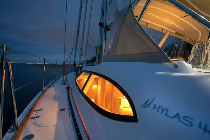 Slide: The Image of Sailing yacht Hylas H48, 2025 model, illuminated cabin at dusk on calm waters. - 8