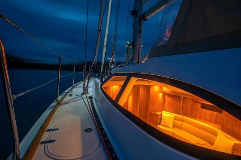 Slide: The Image of Sleek 2025 Hylas H48 yacht at night, illuminated interior, serene ocean backdrop. - 9