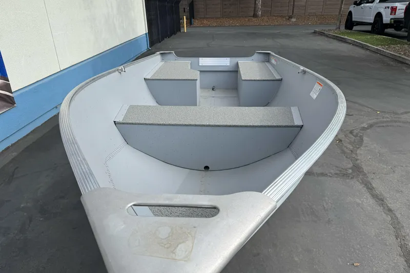 Slide: The Image of 2026 Lund WC 12 aluminum boat with seating, parked outdoors on pavement. - 3