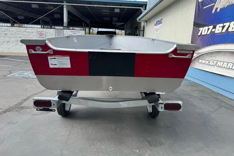 Slide: The Image of 2026 Lund WC 12 boat on trailer, red and silver design, parked outdoors. - 6