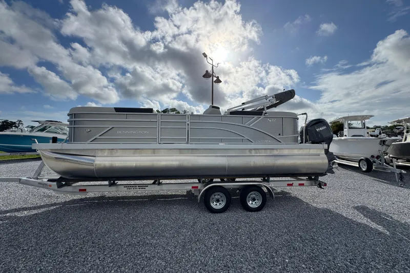 The Image of 2026 Bennington 22 SSR pontoon boat on trailer under cloudy sky. - 1