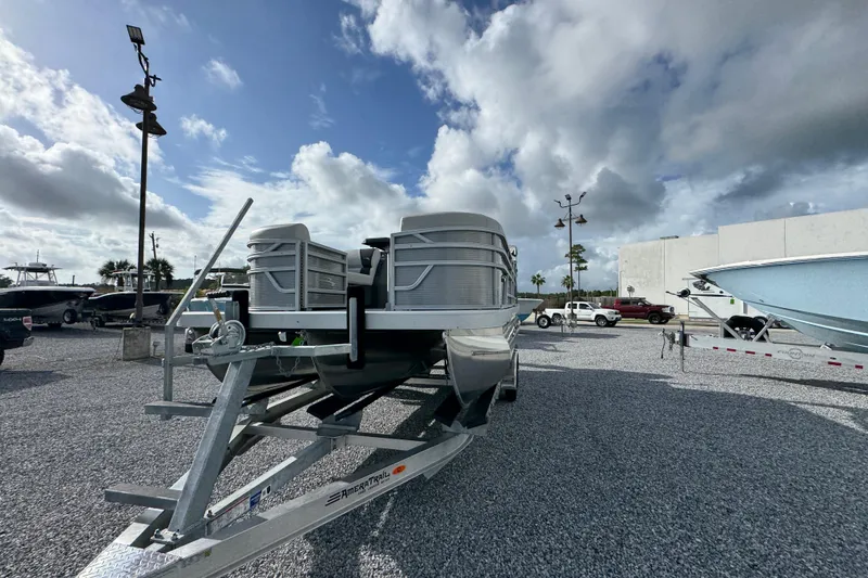 Slide: The Image of 2026 Bennington 22 SSR pontoon boat on trailer under cloudy sky. - 10