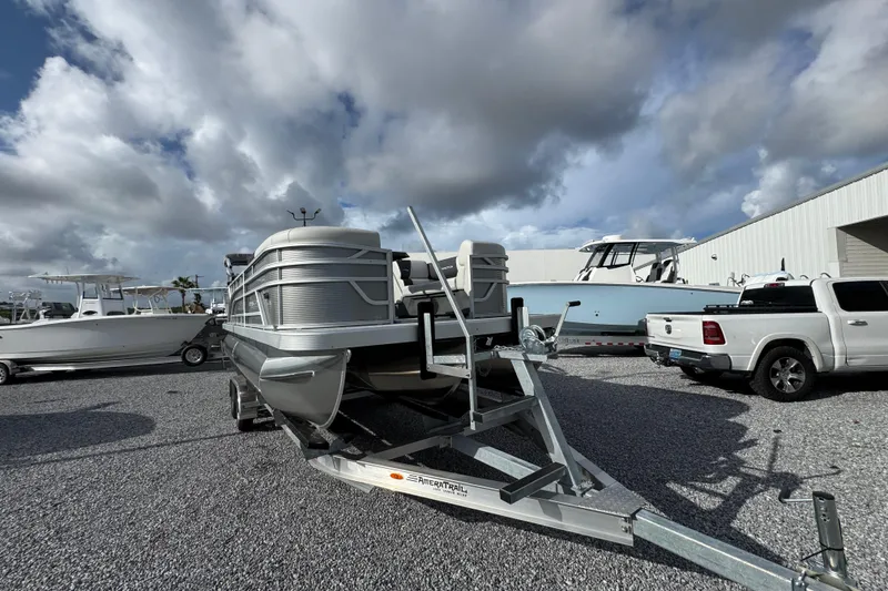 Slide: The Image of 2026 Bennington 22 SSR pontoon boat on trailer, parked outdoors under cloudy sky. - 12