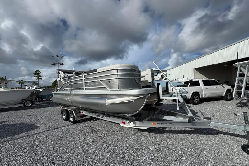Slide: The Image of 2026 Bennington 22 SSR pontoon boat on trailer, parked outdoors under cloudy sky. - 13