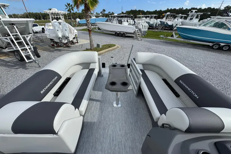 Slide: The Image of 2026 Bennington 22 SSR pontoon boat interior with plush seating and table, displayed outdoors. - 15