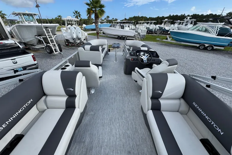 Slide: The Image of 2026 Bennington 22 SSR pontoon boat with luxurious seating, parked among other boats. - 23