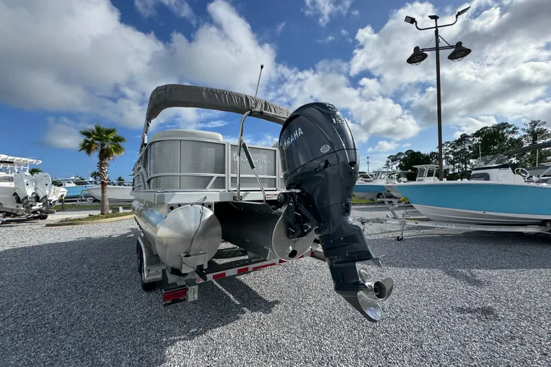 Slide: The Image of 2026 Bennington 22 SSR pontoon boat with Yamaha outboard motor, parked on gravel lot. - 4